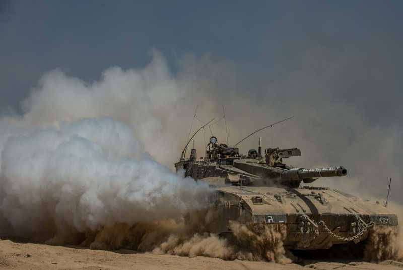  An Israeli Merkava tank runs in the field in southern Israel near the border with Gaza