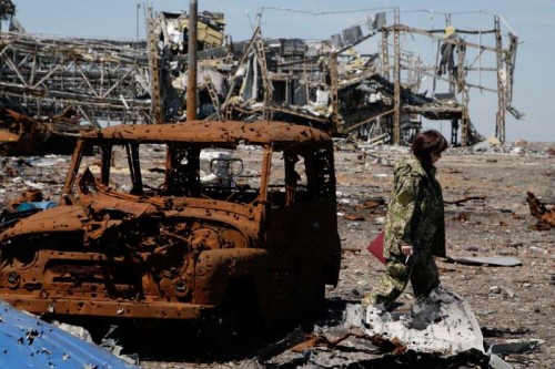  A soldier walks past a wreckage of a car in Donetsk, Ukraine