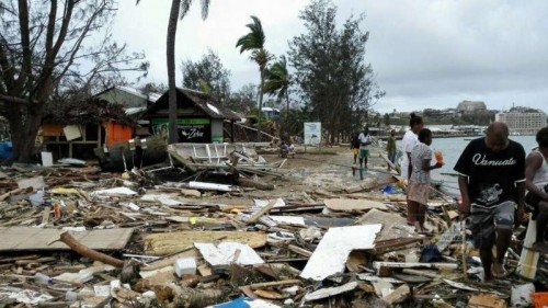 Locals walk past debris after Tropical Cyclone Pam wreaked havoc in Port Vila, Vanuatu, March 15, 2015. The cyclone-hit island nation of Vanuatu declared a state of emergency on Sunday after at least eight people were confirmed killed by Tropical Cyclone Pam, local press reported.