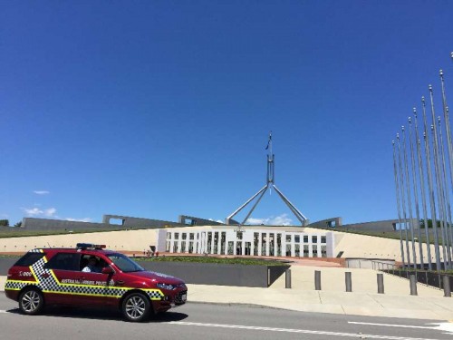 A police patrol car passes the forecourt of the Parliament House hours after a few gunmen took people hostage in a cafe in Sydney CBD, in Canberra, Australia, Dec. 15, 2014. 