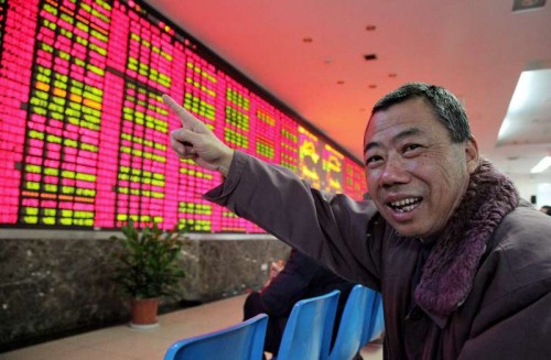 An invester points at an electronic billboard displaying share prices in a stock trading venue in east China's Shanghai, Dec. 3, 2014. China's stocks saw a rise on Wednesday with the benchmark SSE Composite Index and SZSE Component Index closing at 2779.53 points (up 0.58 percent) and 9443.92 points (up 2.96 percent) repectively. 