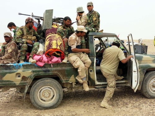 Fighters of Hashid al-Shaabi forces get on a truck at the frontline against Islamic State (IS) militants in the Tharthar lake area, northeast of Fallujah, some 50 km west of Baghdad, on June 01, 2015.