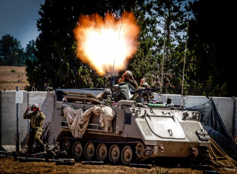 Israeli army soldiers atop of APC fire a mortar in southern Israel near the border with Gaza, on the 12th day of Operation Protective Edge, on July 19, 2014. Two Israeli soldiers were killed in a fire exchange with Palestinian militants who infiltrated Israeli turf through a Gaza tunnel earlier on Saturday, the Israel Defense Forces (IDF) confirmed in a statement.