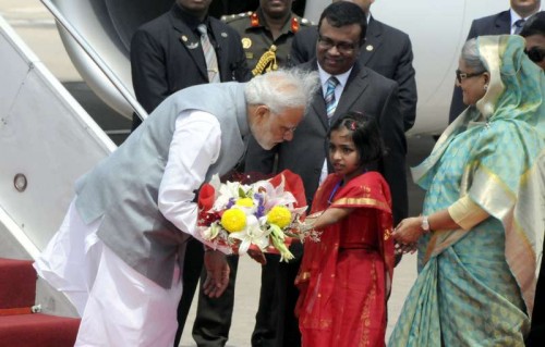 Indian Prime Minister Narendra Modi (L, front) receives a bunch of flowers from a Bangladeshi girl after arriving at the Hazrat Shahjalal International Airport in Dhaka, Bangladesh, June 6, 2015. Indian Prime Minister Narendra Modi arrived in Dhaka on Saturday for a two-day visit to Bangladesh. Prime Minister Sheikh Hasina greeted her counterpart at the Hazrat Shahjalal International Airport with a 19-gun salute.