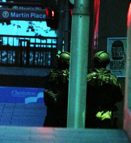  Policemen secure Martin Place in Sydney, Australia, on Dec. 15, 2014. A gunman, who held an unknown number of people hostage in a downtown cafe in Martin Place of Sydney on Monday, has been identified after five hostages managed to flee the hours-long siege. 