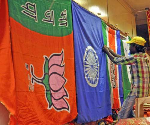 A worker arranges flags of different political parties in Mumbai.