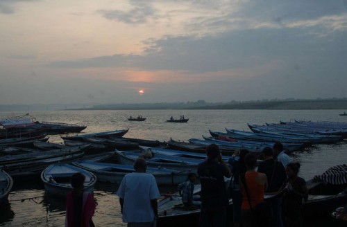 Foreigners click pictures of sunrise on the banks of Ganga river in Varanasi.