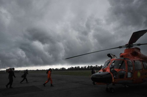 Search and Rescue (SAR) team members bring body bags to helicopter in bad weather at Pangkalan Bun, in Central Kalimantan, Indonesia, Dec. 31, 2014. Indonesian authorities confirmed object and corpses spotted were from the missing AirAsia plane and they will continue to search on Wednesday. 