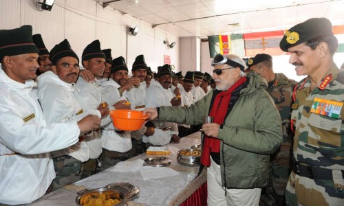 The Prime Minister, Shri Narendra Modi sharing sweets with Indian Army Jawans on the occasion of Diwali, at Siachen Base Camp on October 23, 2014. The Chief of Army Staff, General Dalbir Singh is also seen.