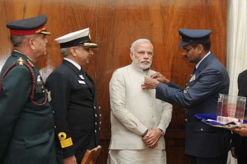 The Officers of the Kendriya Sainik Board pinning a flag on the Prime Minister, Shri Narendra Modi during the Armed Forces Flag Day, in New Delhi on December 04, 2014.
